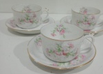 LIMOGES - CONJUNTO DE TRÊS XÍCARAS EM PORCELANA FRANCESA COM DECORAÇÃO FLORAL. PEÇA MARCADA NA BASE. UM PIRES COM BICADO. MEDINDO A XÍCARA 5.5 X 8 X 11 CM E O PIRES 14 CM