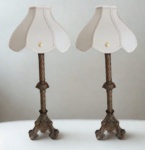 MARAVILHOSO PAR DE TOCHEIROS/ABAJUR, EXECUTADOS EM BRONZE, FUSTE TORCIDO EM MOVIMENTO HELICOIDAL, INTERROMPIDO POR DISCO ELIPSOIDE, ENVOLTO POR TRÊS RESERVAS OVAIS CONTENDO FLORES, CIRCUNDADO POR APLICAÇÕES DE ROSETAS, BOBECHE EM FORMA DE FOLHAGEM, BASE TRÍPODE CONTENDO EM CADA UMA DAS FACES O BRASÃO DO IMPÉRIO BRASILEIRO, CENTRALIZADO POR VOLUTAS, FLORES E PINHAS, PERNAS NA FORMA DE ANIMAL HÍBRIDO COM CORPO DE FELINO E CARA DE PÁSSARO, DEITADO SOBRE GRANDE ENROLAMENTO - ( PARTE ELETRICA NOVA E CÚPULAS NOVAS EM PERFEITO ESTADO DE CONSERVAÇÃO ) - MEDIDAS: ALT. 54 X COMP. 19 X LARG. 19 CM.