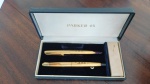 ANTIGO CONJUNTO DE CANETAS PARKER 45 SIGNET FOLHADAS A OURO EM SUA CAIXA ORIGINAL - USADAS COM GRAVAÇAO DAS INICIAIS M. A. B. NO CORPO DAS CANETAS - NECESSITAM LIMPEZA E TROCA DAS CARGAS - NO ESTADO CONFORME FOTOS