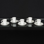 PORCELANA, Cinco (5) xícaras para café, brancas, arremates com frisos prateados, pires octogonais faltando umdeles, manufatura SCHMIDT (Pomerode, SC; Mauá, SP; Campo Largo, PR, fundada em 1945, ainda em atividade,maior fábrica de porcelana da América Latina), sinais de uso, vide foto.