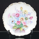 PORCELANA, um (1) prato decorativo com ornamentação floral policromada, assinado K. YAMAUCHI,arremates a ouro, quebrado na borda e pequena trinca, marca de origem JAPAN, medindo 21,5 cm diâmetro, vide foto.