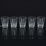 DEMI CRISTAL, cinco (5) copos, incolores e translúcidos, ligeiramente obcônicos, moldado em dedão, fundoestrelado, medindo 6 cm diâmetro e 7,5 cm altura, sinais de uso, vide foto.