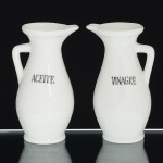 PORCELANA, par (2) galhetas na tonalidade branca, com as legendas, ACEITE e VINAGRE, medindo 11,5 cmaltura, sinais de uso, vide foto.
