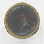 DIVERSOS, uma (1) base, comemorativa a Coroação da Rainha Elizabeth II, ano 1952, confeccionada emimitação de tortoise, envidraçada, monture em metal relevada em elementos vegetalistas, base trípode em volutas,medindo 8,5 cm diâmetro, sinais de uso, vide foto.