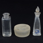 VIDRO, três (3) itens: 2 flacons de parfum, vazios, incolores e translúcidos, um da marca RKANITZ, tampa noformato de folha com quebradinho na ponta, medindo 8,5 cm altura, outro quadrangular sem tampa, ausência de marca,medindo 6 cm altura; 1 caixa com tampa, modelagem relevada na forma de galo, acetinada, ausência de marca, medindo4,5 cm diâmetro, todos os itens com sinais de uso, vide foto.