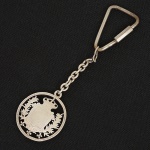 PRATA, um (1) chaveiro, confeccionado com aproveitamento de antiga moeda portuguesa em prata, medindo 3 cmdiâmetro mais olhal e corrente, também em prata, fecho em metal prateado, peso somente da prata sem o fecho 10,3 gr.,sinais de uso, vide foto.