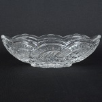 VIDRO, um (1) covilhete, incolor e translúcido, formato de naveta, modelado em sulcos, losangos e estrelas,medindo 20 x 9 x 6 cm, sinais de uso, vide foto.