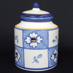 CERÂMICA, um (1) pote com tampa, ornamentação floral pintada a mão, tonalidades azul e amarelo sobre fundobranco, selo da P. Brasil Cerâmica,medindo 21 cm altura, sinais de uso, vide foto.