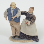 ESCULTURA, um (1) grupo escultórico figurativo representando casal de anciões, confeccionado em resinapolicromada, vestes em tecido, medindo 19 cm altura, vide foto.