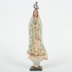 ARTE SACRA, uma (1) imaginária de Nossa Senhora de Fátima, confeccionada em resina policromada, olhos devidro, coroa em metal dourado (amassada e com sinais de azinhavre), medindo 26 cm altura, vide foto.