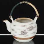 PORCELANA JAPONESA, um (1) bule para chá, ornamentação pintada a mão em policromia com riquixá eelementos vegetalistas, faixa com detalhes a ouro, alça em tresse de fibra sintética envolvendo bambu vergado, fundocom marca de origem KUTANI em caracteres, falta a tampa, medindo 10,5 cm diâmetro, sinais de uso, vide foto.