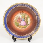 PORCELANA ALEMÃ, um (1) prato decorativo ornado com cena galante em policromia baseada na obra deFRAGONARD (Jean Honoré Fragonard, Grasse 1732 Paris 1806, pintor, desenhista e gravurista francês, estilo Rococó,conhecido pela exuberância e hedonismo de sua obra, pinturas do gênero com atmosfera de intimidade e erotismo),fundo degrade do marrom ao branco, borda com faixa na tonalidade azul, generosos arremates a ouro, marca BAVARIA,medindo 24,5 cm diâmetro, vide foto.