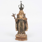 ARTE-SACRA, Santa Rita de Cássia em madeira entalhada, policromada a ouro, provavelmente Portugal, com uma coroa em metal, uma cruz em dadeira na mão direita e olhos de vidro. Apresenta desgastes natural do tempo, na policromia e coroa necessita de restauro. Século XVII/XIX. Alt. total com a coroa 19,5cm.
