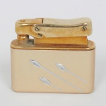 COLECIONISMO, um (1) isqueiro da marca COLIBRI  MONOPOL, acondicionado na caixa, não aparenta uso, confeccionado em metal dourado, detalhes prateados, vide foto.