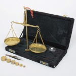 DIVERSOS, uma (1) antiga balança, acondicionada em estojo, possui os pesos, sinais de uso, vide foto.