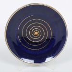 PORCELANA, uma (1) fruteira na tonalidade azul cobalto com ornamentação espiralada a ouro, base trípode, sem marca de manufatura aparente, medindo 18 cm diâmetro, desgastes na borda, sinais de uso, vide foto.