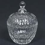 VIDRO, um (1) porta confeitos com tampa, incolor e translúcido, moldado em caneluras e esferas, pega da tampa na forma de baga, fundo em dália, medindo 14,5 cm altura, sinais de uso, vide foto.