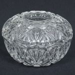 VIDRO, um (1) porta confeitos com tampa, incolor e translúcido, modelagem geometrizada, medindo 13 cm diâmetro e 8,5 cm altura, sinais de uso, vide foto.