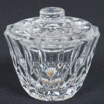 CRISTAL, uma (1) pequena molheira com tampa, incolor e translúcida, modelagem geometrizada, medindo 7 cm altura, sinais de uso, vide foto.