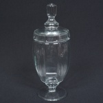 VIDRO, uma (1) compoteira de pé baixo, incolor e translúcida, bojo moldado em gomos, pega da tampa na forma de baga, base em bolacha, medindo 29,5 cm altura, sinais de uso, vide foto.