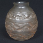 VIDRO FRANCÊS, um (1) vaso bojudo e acetinado, com faixas relevadas em gazelas e flores, assinado R. LALIQUE (René Jules Lalique; 1860, Ay; 1945, Paris; em 1872 aos 12 anos ingressou no College Turgot, onde teve aulas de desenho; em 1876 tornou-se aprendiz do ourivesw Louis Aucoc; estudou na École des Arts Decoratifs de Paris e no Sydenham Arts College em Londres; trabalhou como design para diversos joalheiros: Jacta, Boucheron, cartier e Gariod; em 1885 gerenciou a oficina do joalheiro Jules destape; em 1886 abriu a própria joalheria; também ficou conhecido por suas criações em vidro; decorou o Grande Salão do Transatlântico SS Normandie; a Igreja Anglicana de St Matthew; foi o primeiro a esculpir em vidro, como: as portas do Hotel Alberto I; as fontes do Champs-Elysées; criou diversos frascos de perfume; em 1914 com a Primeira Grande Guerra converteu a sua fabrica de vidro para produzir material médico; em 1921 abriu uma nova fábrica; em 1925 participou da Exposição Internacional de Artes decorativas e Industriais Modernas com uma fonte de 14 metros de altura desenhada por ele; fez as decorações em vidro: do trem Expresso do Oriente; do Palácio Imperial do Principe Asaka e da Galeries Lafayette em Paris; em 1939 com a Segunda Grande Guerra, adaptou novamente sua fabrica para os esforços de guerra), medindo 17 cm altura, vide foto.