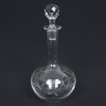 VIDRO, uma (1) licoreira, incolor e translúcida, com tampa facetada, bojo pirografado, medindo 28 cm altura, traz lascado no gargalo, sinais de uso, vide foto.