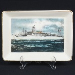 FAIANÇA, um (1) covilhete retangular, ornamentação policromada, representando navio S. S. Brasil, pequena trinca e bicado na borda, arremates com frisos a ouro com sinais de desgaste, medindo 19 x 13,5 cm, vide foto.