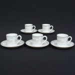 PORCELANA, cinco (5) xícaras para café com seis pires, ornamentação floral policromada em tons pasteis, arremates com frisos prateados, manufatura SCHMIDT (Pomerode, SC; Mauá, SP; Campo Largo, PR, fundada em 1945, ainda em atividade, maior fábrica de porcelana da América Latina), sinais de uso, vide foto.