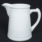 PORCELANA, uma (1) cremeira na tonalidade branca, formato ligeiramente cônico, manufatura SCHMIDT (Pomerode, SC; Mauá, SP; Campo Largo, PR, fundada em 1945, ainda em atividade, maior fábrica de porcelana da América Latina), medindo 13,5 cm altura, sinais de uso, vide foto.