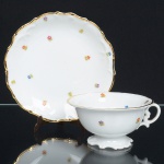 PORCELANA PORTUGUESA, uma (1) xícara de chá com seu respectivo pires, ornamentação floral policromada, arremates a ouro, manufatura VISTA ALEGRE (fundada em 1824, pelo negociante, lavrador, industrial e político, José Ferreira Pinto Basto, através de alvará concedido por D. João VI, tendo seu fundador associado a fábrica os seus 15 filhos, ficando a sociedade denominada Ferreira Pinto & Filhos; cinco anos mais tarde recebe o título real pelo reconhecimento de sua arte e sucesso, ficando conhecida como Real Fábrica da Vista Alegre, começou no fabrico de vidros enquanto se empenhava em esforços para a produção de porcelana, os primeiros ensaios conseguidos foram imperfeitos denominado loiça de pó de pedra, através de boas relações com a fábrica francesa de Sevres conseguiu as receitas para o fabrico de porcelana, somente em 1832, por sorte, é encontrado um jazigo de caulim situado em Aveiro, próximo a Ílhavo, a partir desta data o fabrico de porcelana foi se aperfeiçoando em Portugal, 1851 expôs com sucesso no Palácio de Cristal em Londres; 1852 D. Fernando II visita a fábrica e encomenda uma baixela completa; 1867 recebeu sua primeira premiação na Exposição Universal de Paris; 1880 interrompe a produção de vidros para se dedicar exclusivamente a porcelana; 1964 inauguração do Museu Histórico da Vista Alegre; ainda em funcionamento), medindo a maior peça 15,5 cm diâmetro, ideal para coleção de cristaleira, vide foto.