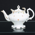 PORCELANA PORTUGUESA, um (1) bule para chá (bico quebrado e colado), ornamentação floral policromada, arremates a ouro, manufatura VISTA ALEGRE (fundada em 1824, pelo negociante, lavrador, industrial e político, José Ferreira Pinto Basto, através de alvará concedido por D. João VI, tendo seu fundador associado a fábrica os seus 15 filhos, ficando a sociedade denominada Ferreira Pinto & Filhos; cinco anos mais tarde recebe o título real pelo reconhecimento de sua arte e sucesso, ficando conhecida como Real Fábrica da Vista Alegre, começou no fabrico de vidros enquanto se empenhava em esforços para a produção de porcelana, os primeiros ensaios conseguidos foram imperfeitos denominado loiça de pó de pedra, através de boas relações com a fábrica francesa de Sevres conseguiu as receitas para o fabrico de porcelana, somente em 1832, por sorte, é encontrado um jazigo de caulim situado em Aveiro, próximo a Ílhavo, a partir desta data o fabrico de porcelana foi se aperfeiçoando em Portugal, 1851 expôs com sucesso no Palácio de Cristal em Londres; 1852 D. Fernando II visita a fábrica e encomenda uma baixela completa; 1867 recebeu sua primeira premiação na Exposição Universal de Paris; 1880 interrompe a produção de vidros para se dedicar exclusivamente a porcelana; 1964 inauguração do Museu Histórico da Vista Alegre; ainda em funcionamento), medindo 18 cm altura, ideal para coleção de cristaleira, vide foto.