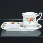 PORCELANA, uma (1) xícara de chá com aba para biscoitos, ornamentação floral policromada, detalhes a ouro, marcada LE GOURMET, medindo 21,5 cm comprimento, sinais de uso, vide foto.