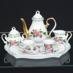 PORCELANA, conjunto tete a tete para café com seis (6) itens: 1 bandeja; 1 bule; 1 açucareiro; 1 cremeira e 2 xícaras, ornamentação policromada representando flores e frutas, arremates com frisos a ouro, sem marca de manufatura aparente, medindo a maior peça 26 x 16,5 cm, ideal para coleção de cristaleira, sinais de uso, vide foto.