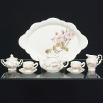 PORCELANA, conjunto tete a tete para café com seis (6) itens: 1 bandeja; 1 bule; 1 açucareiro; 1 cremeira e 2 xícaras, ornamentação floral policromada, medindo a maior peça 29,5 x 20,5 cm, sem marca de manufatura aparente, ideal para coleção de cristaleira, vide foto.