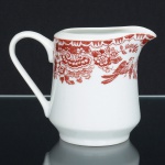 PORCELANA, uma (1) cremeira, formato ligeiramente cônico, ornamentação na tonalidade ocre sobre fundo branco, com pássaros e flores, manufatura REAL (Mauá, SP, 1943 a 1994), medindo 9 cm altura, sinais de uso, vide foto.