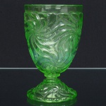 VIDRO FRANCÊS, um (1) copo de pé baixo, moldado em sulcos espiralados, marcado em relevo na base BACCARAT  DEPOSE, tonalidade verde, translúcido, medindo 13 cm altura, ideal para coleção de cristaleira, sinais de uso vide foto.
