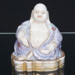 LOUÇA, uma (1) escultura representando Deus HOTEI (um dos 7 Deuses da Boa Sorte, Fortuna e Felicidade, integrantes do Shichi Fukujin, segundo o Xintoísmo, Mitologia e Folclore Japonês é o deus da felicidade e prosperidade), pintado a mão em policromia, arremates a ouro, boca fechada, sem marca de manufatura aparente, medindo 12 cm altura, sinais de uso, vide foto.