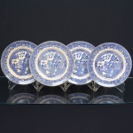 FAIANÇA INGLESA, quatro (4) pratos rasos, ornamentação dita WILLON (Segundo a lenda chinesa: Um certo Mandarim tinha uma leal e devotada filha, possuidora de rara beleza. Certo dia, em que descobre que ela estava apaixonada por um carteiro que lhe fazia a corte, e que era por ela correspondida, expulsa a filha de casa e roga-lhe uma praga: que ao ser trocado o primeiro beijo pelo casal, eles se transformariam em dois pombos), também conhecida como pombinhos, manufatura WOOD & SONS Ltd. (fundada em 1865, funcionou na Potteries New Wharf em Trent e mais tarde na Pottery Stanley em Burlem, fechou em 2005), tonalidade azul sobre fundo branco, medindo 23 cm diâmetro, possui o craquelê característico do envelhecimento de toda a faiança, sinais de uso, vide foto.