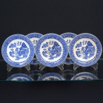 FAIANÇA INGLESA, cinco (5) pires descasados sem as xícaras, ornamentação dita WILLON (Segundo a lenda chinesa: Um certo Mandarim tinha uma leal e devotada filha, possuidora de rara beleza. Certo dia, em que descobre que ela estava apaixonada por um carteiro que lhe fazia a corte, e que era por ela correspondida, expulsa a filha de casa e roga-lhe uma praga: que ao ser trocado o primeiro beijo pelo casal, eles se transformariam em dois pombos), também conhecida como pombinhos, manufatura WOOD & SONS Ltd. (fundada em 1865, funcionou na Potteries New Wharf em Trent e mais tarde na Pottery Stanley em Burlem, fechou em 2005), tonalidade azul sobre fundo branco, medindo 15 cm diâmetro, possuem o craquelê característico do envelhecimento de toda a faiança, sinais de uso, vide foto.