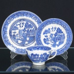 FAIANÇA INGLESA, um (1) trio para chá (xícara, pires e prato de bolo), ornamentação dita WILLON (Segundo a lenda chinesa: Um certo Mandarim tinha uma leal e devotada filha, possuidora de rara beleza. Certo dia, em que descobre que ela estava apaixonada por um carteiro que lhe fazia a corte, e que era por ela correspondida, expulsa a filha de casa e roga-lhe uma praga: que ao ser trocado o primeiro beijo pelo casal, eles se transformariam em dois pombos), também conhecida como pombinhos, manufatura WOOD & SONS Ltd. (fundada em 1865, funcionou na Potteries New Wharf em Trent e mais tarde na Pottery Stanley em Burlem, fechou em 2005), tonalidade azul sobre fundo branco, medindo a maior peça 18 cm diâmetro, possui o craquelê característico do envelhecimento de toda a faiança, sinais de uso, vide foto.
