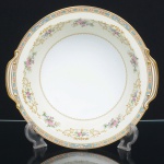 PORCELANA JAPONESA, uma (1) saladeira tipo bowl, ornamentação floral policromada, borda com faixa na tonalidade azul claro e elementos vegetalistas em policromia, arremates a ouro, manufatura NORITAKE (1858 - Japão assinou o Tratado de Amizade e Comércio com os EUA, Holanda, Rússia, Reino Unido e França; 1867 fim do Shogunato e início da era Meiji; 1876 - Morimura-Kumi formada em Tóquio para exportação Os Morimuras & The Okuras unidos, a Companhia Hinode se estabelece na cidade de Nova York para o varejo; 1879 - A Companhia Hinode fecha. Morimura Bros & Co., se estabelece em Nova York; 1880 - Hiroses juntou-se a Morimura-Kumi em Tóquio; 1882 - Morimura Bros & Co., decidiu ser o atacadista; 1884 Morimura-Kumi subcontrata atelieres de decoração em porcelana nas cidades de Tokyo, Nagoya e Kyoto; 1918 - Morimura-Kumi é reorganizada como Morimura Bros, Inc.; 1921 - Morimura Bros de New York é incorporada a Morimura Bros, Inc. De Tokyo; 1947 - Noritake Co., Inc. com sede em Nova York; 1981 - Nome japonês da Companhia alterado para Noritake Co. Limited), modelo COLBY, medindo 25,5 cm diâmetro mais as alças e 7 cm altura, sinais de uso, vide foto.