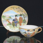 PORCELANA JAPONESA, uma (1) xícara para chá, dita casca de ovo, ornamentação policromada na técnica Moriage, representando paisagem lacustre com figuras e flor de cerejeira, ponte, montanhas, casarios e outros elementos vegetalistas, arremates a ouro, marca MIKADO, ideal para coleção de cristaleira, sinais de uso, vide foto.