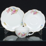 PORCELANA POLONESA, um (1) trio para chá (xícara, pires e prato de bolo), ornamentação floral policromada, arremates a ouro, manufatura KPM (Krister Porzellan-Manufaktur 1831 a 1920, fundada no ano de 1831 por Carl Franz Krister; em 1867 foi premiado na Exposição Internacional de Paris mesmo ano da sua morte; em 1920 mudou a razão social para Krister Porzellan-Manufaktur AG 1920 a 1952; em 1921 foi autorizado pelo governo a produzir moeda de porcelana (Notgeld); em 1945 depois da Segunda Guerra Mundial o território deixou de ser alemão e passou a integrar a Polônia; em 1952 foi nacionalizada e passou a ser Fabryka Porcelany Krzysztof 1952 a 1995; em 1995 mudou a razão social para Fabryka Porcelany Krzysztof SA, funciona até a atualidade), ideal para coleção de cristaleira, sinais de uso, vide foto.