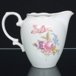 PORCELANA POLONESA, uma (1) cremeira, ornamentação floral policromada, arremates a ouro, manufatura KPM (Krister Porzellan-Manufaktur 1831 a 1920, fundada no ano de 1831 por Carl Franz Krister; em 1867 foi premiado na Exposição Internacional de Paris mesmo ano da sua morte; em 1920 mudou a razão social para Krister Porzellan-Manufaktur AG 1920 a 1952; em 1921 foi autorizado pelo governo a produzir moeda de porcelana (Notgeld); em 1945 depois da Segunda Guerra Mundial o território deixou de ser alemão e passou a integrar a Polônia; em 1952 foi nacionalizada e passou a ser Fabryka Porcelany Krzysztof 1952 a 1995; em 1995 mudou a razão social para Fabryka Porcelany Krzysztof SA, funciona até a atualidade), medindo 14 cm altura, sinais de uso, vide foto.