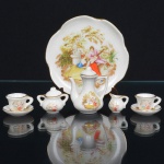 PORCELANA, conjunto tete a tete miniatura com seis (6) itens: 1 bandeja; 1 bule; 1 açucareiro; 1 cremeira e 2 xícaras, ornamentação policromada com cena de galanteio, inspirada na obra de FRAGONARD (Jean Honoré Fragonard, Grasse 1732 Paris 1806, pintor, desenhista e gravurista francês, estilo Rococó, conhecido pela exuberância e hedonismo de sua obra, pinturas do gênero com atmosfera de intimidade e erotismo), medindo a maior peça 10 cm diâmetro, ideal para coleção de cristaleira, vide foto.
