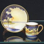 PORCELANA JAPONESA, uma (1) antiga xícara para café, ornamentação pintada a mão em policromia com paisagem lacustre e casebre, generosos arremates a ouro, técnica Moriage, manufatura NORITAKE (1858 - Japão assinou o Tratado de Amizade e Comércio com os EUA, Holanda, Rússia, Reino Unido e França; 1867 fim do Shogunato e início da era Meiji; 1876 - Morimura-Kumi formada em Tóquio para exportação Os Morimuras & The Okuras unidos, a Companhia Hinode se estabelece na cidade de Nova York para o varejo; 1879 - A Companhia Hinode fecha. Morimura Bros & Co., se estabelece em Nova York; 1880 - Hiroses juntou-se a Morimura-Kumi em Tóquio; 1882 - Morimura Bros & Co., decidiu ser o atacadista; 1884 Morimura-Kumi subcontrata atelieres de decoração em porcelana nas cidades de Tokyo, Nagoya e Kyoto; 1918 - Morimura-Kumi é reorganizada como Morimura Bros, Inc.; 1921 - Morimura Bros de New York é incorporada a Morimura Bros, Inc. De Tokyo; 1947 - Noritake Co., Inc. com sede em Nova York; 1981 - Nome japonês da Companhia alterado para Noritake Co. Limited), marca estampada com o símbolo KOMARU (superação de dificuldades), encimada pela legenda NORITAKE, abaixo em posição semi circular a marca de origem Made in Japan, registrada no ano de 1908 em Londres, para peças destinadas a exportação, principalmente para o Reino Unido, ideal para coleção de cristaleira, vide foto.