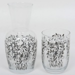 VIDRO, conjunto com dois (2) itens, verre et bouteille d' eau, incolores e translúcidos, esmaltação vegetalista na tonalidade preta, tipo silhueta, medindo 20 cm altura, sinais de uso, vide foto.