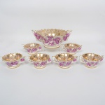 FAIANÇA, conjunto para salada com sete (7) itens: 1 bowl e 6 taças (uma das taças com a asa quebrada), ornamentação floral policromada, generosos arremates a ouro, selo e marca da manufatura WEISS (São José dos Campos, SP, 1941 a 1995, empresa que nasceu da capacidade criativa de Inês Weiss, que desenvolveu uma pintura colorida e exuberante, inicialmente pintava peças da Fábrica Santo Eugênio, com a saída do seu marido Roberto Weiss e do seu cunhado Mário Weiss da Fábrica Santo Eugênio para fundar a Irmãos Weiss, Inês passou a decorar as peças artesanalmente entre os anos 40/60, da própria fabrica do marido e do cunhado, entre as décadas de 60/90 a produção foi industrializada), vendida à época no BAZAR AMÉRICA (Rua Uruguaiana 38 e 40), medindo respectivamente 22 cm diâmetro e 10,5 cm altura; 11 cm diâmetro e 5,5 cm altura, sinais de uso, vide foto.