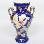 FAIANÇA, um (1) imponente vaso floreiro bojudo, ornamentação floral pintada a mão em policromia sobre fundo azul cobalto, generosos arremates a ouro já com falhas, manufatura ZAPPI (Giuseppe Zappi, renomado ceramista italiano, natural de Ímola, veio para o Brasil contratado por Romeo Ranzini para auxiliar na implantação da Fabrica Santa Catharina em São Paulo; com o término do contrato, passou a prestar assessória a outras fábricas; em 1918 abriu sua própria fábrica no bairro de Vila Prudente, na Rua chamada à época Boacica, perto do córrego das vacas; em 1922 adquiriu a Cerâmica Villa Prudente no mesmo bairro; sua fábrica ganhou notoriedade internacional e conquistou diversas premiações em Exposições, como: Londres (1935); Bruxelas (1937); Pistoia (1938) e Paris (1939); em 1950 com seu falecimento, seu filho Mário Zappi assumiu a fabrica; em 1960 encerrou as atividades, utilizou dois outros nomes fantasias como YARA e RAINHA), medindo 36 cm altura, sinais de uso, vide foto.