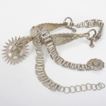 TRALHA PARA MONTARIA, uma (1) espora da marca EBERLE (Abramo Eberle 1880, Monte Magrè 1945, Caxias do Sul, veio com uma das primeiras levas de imigrantes italianos para o Brasil em 1884 junto com seus pais Giuzeppe Eberle e Luigia Zanrosso, seu pai abriu uma pequena funilaria mas como tinha que trabalhar na lavoura quem cuidava era a mãe e o pequeno Abramo ajudava na funilaria; em 1896 quando o pai resolveu vender a funilaria para concentrar os esforços da família na lavoura Abramo, com 16 anos de idade, se propôs a comprá-la do pai, em 1918 já com o nome Abramo Eberle & Cia iniciou a fabricação de talheres e utensílios de mesa, morreu em 1945 com 65 anos de idade e os filhos deram continuidade aos negócios até 1984 quando venderam para o Grupo Zivi), confeccionado em ALPACA (liga metálica com baixíssimo teor em prata), ornamentação relevada em perolados, volutas e elementos vegetalistas, medindo 20 cm, (o termo tralha para montaria é usado em vários rincões pelo Brasil afora, principalmente pelos colecionadores de apetrechos para montaria, não se trata de uma palavra desmerecedora do objeto, muito pelo contrário é uma tradição de linguajar que para muitos colecionadores é motivo de orgulho), sinais de uso, vide foto.